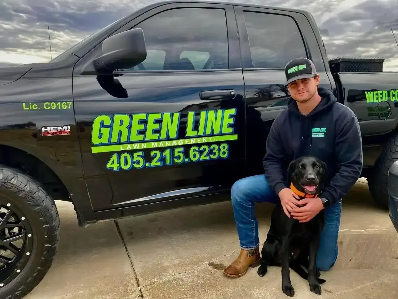 Green Line owner Dalton Smith with his dog in front of a Green Line service truck