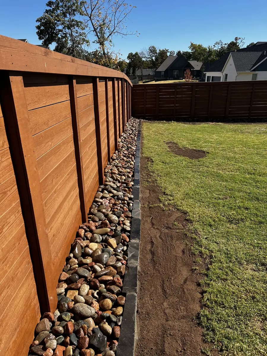 Gravel drainage route finished beside a residential fence