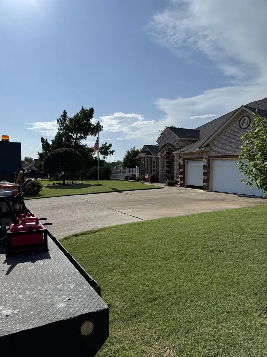 Maintained residential front lawn with Greenline mowing equipment parked at the curb