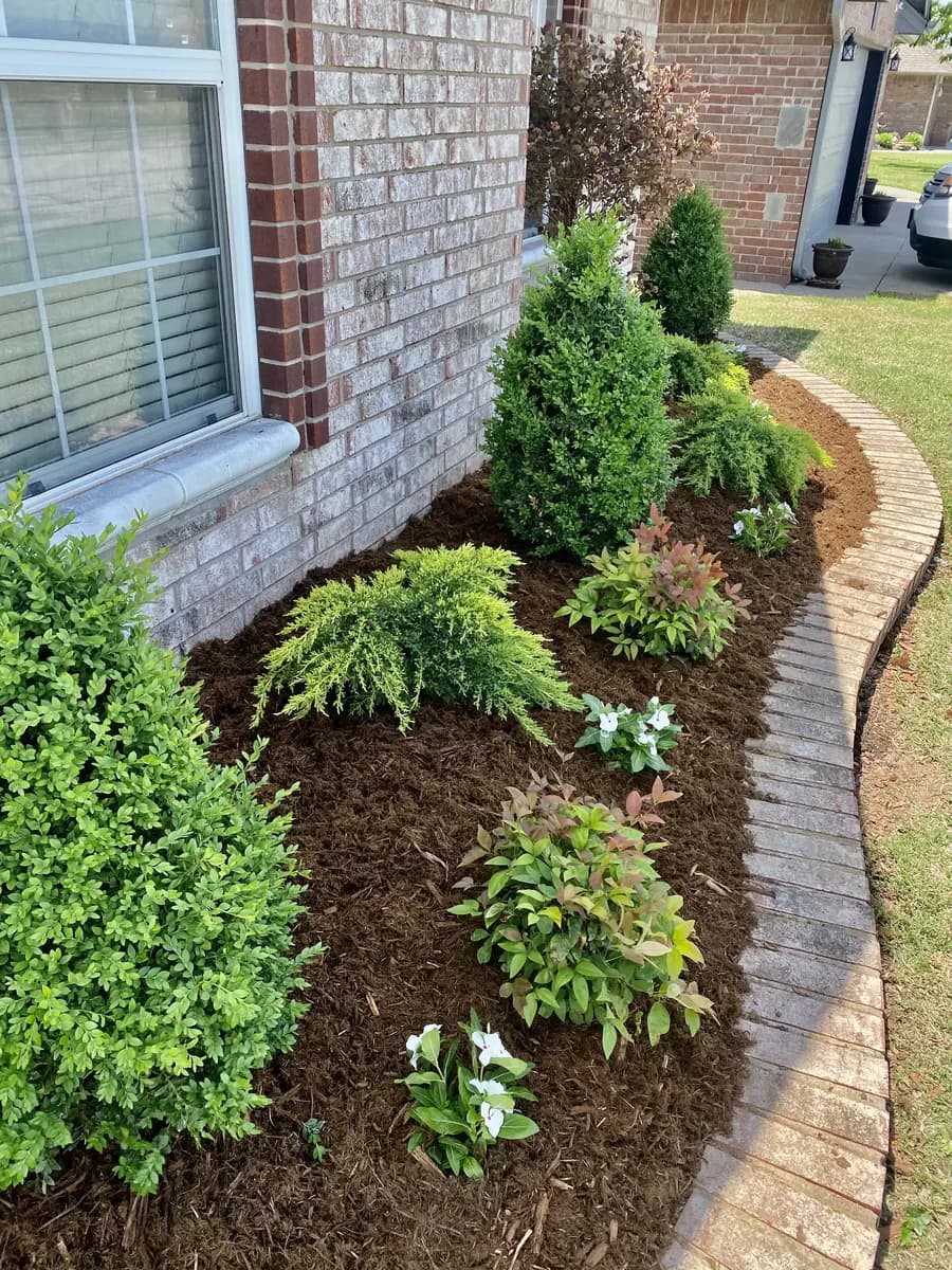Fresh shrubs and mulch in a completed front landscape